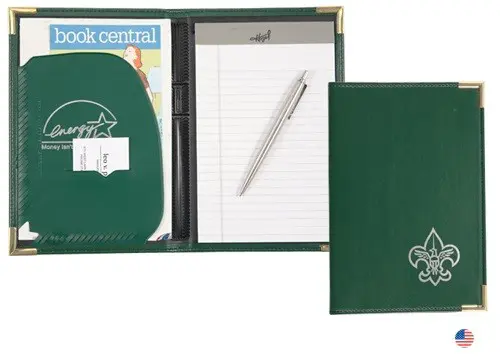 A green folder with a pen and note pad inside of it.