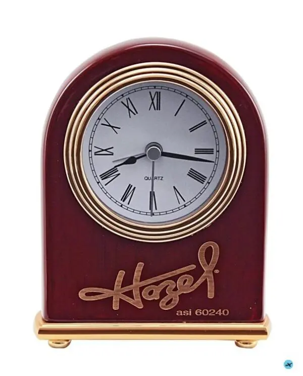 A red clock with roman numerals and gold lettering.