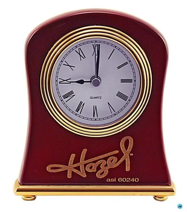 A red clock with gold lettering and roman numerals.