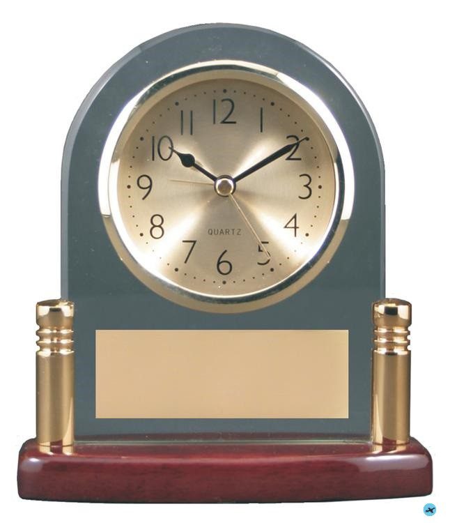 A clock with gold numbers and a plaque.