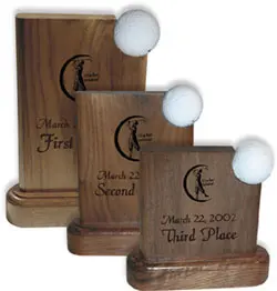 A series of three wooden trophies with white balls.