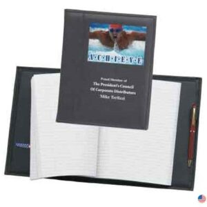 A book with a pen and pencil on top of it.