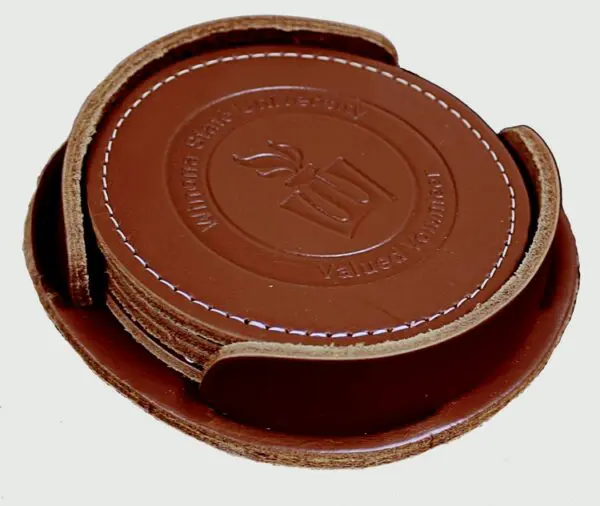 A brown leather coaster set with the number 2 5.