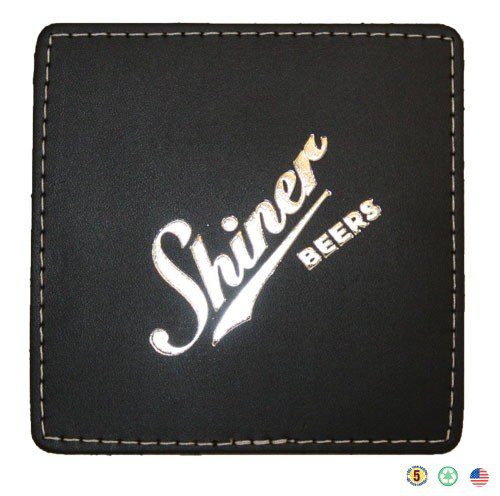 A black leather coaster with the name shiner beers on it.