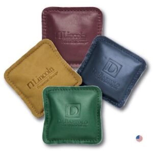 A group of four square leather coasters in different colors.