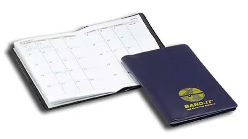 A blue passport and calendar sitting on top of the table.